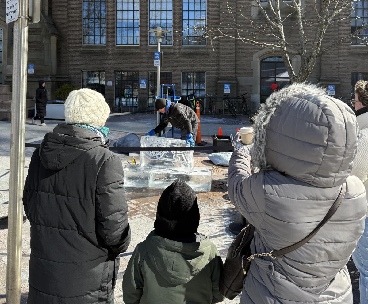 families gather to watch the ice sculptor work