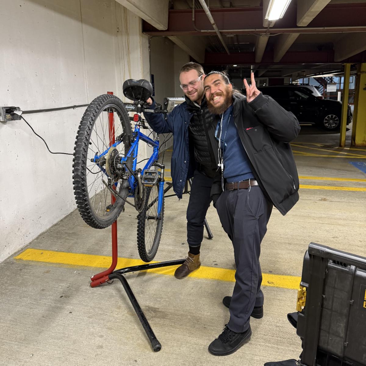 tune up biker poses with bike mechanic